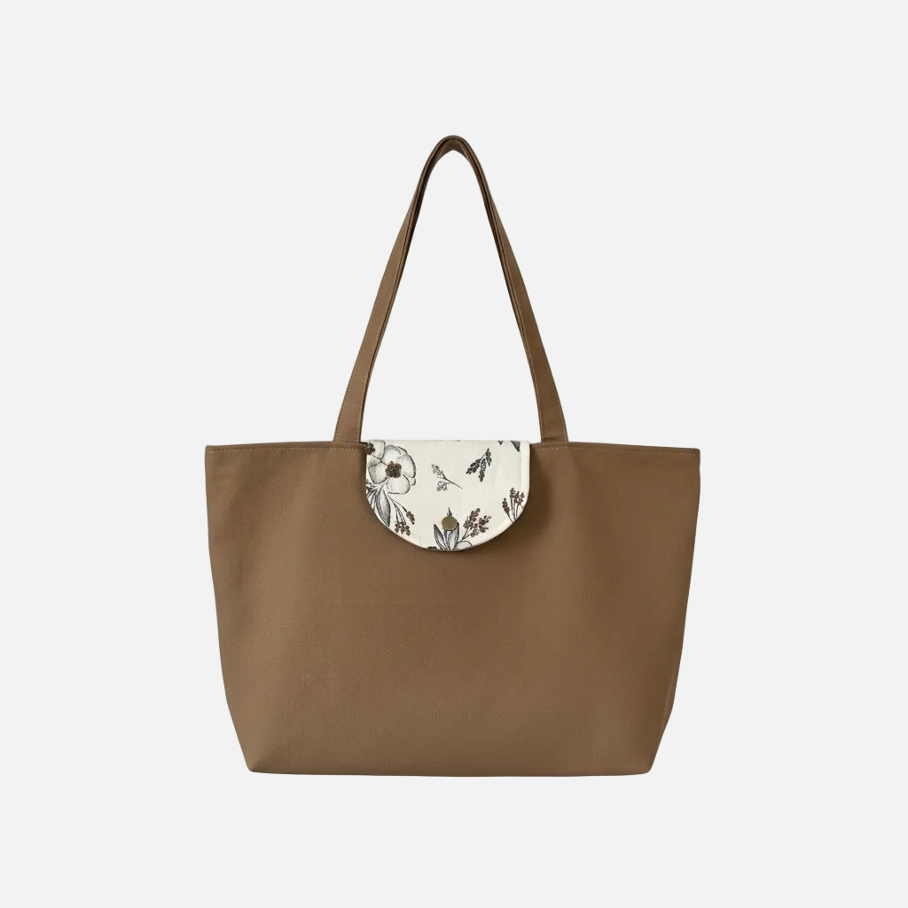 Brown tote bag with floral flap on a white background