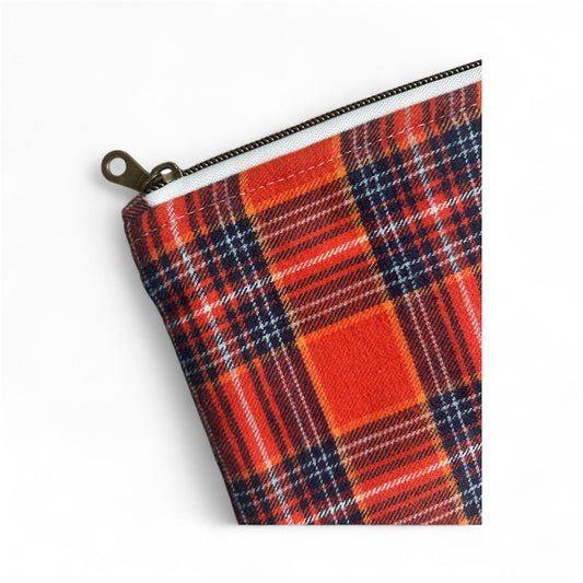 Close-up of red plaid canvas pouch with metal zipper on white background