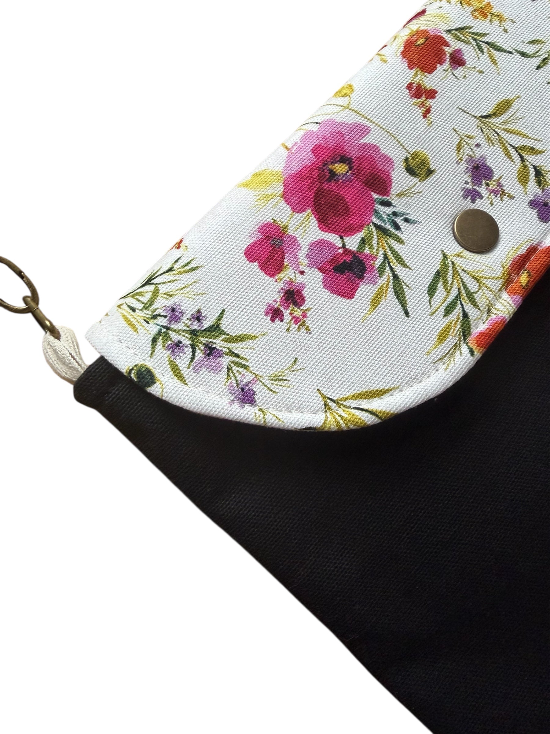 Close-up of black canvas crossbody bag with floral print detail