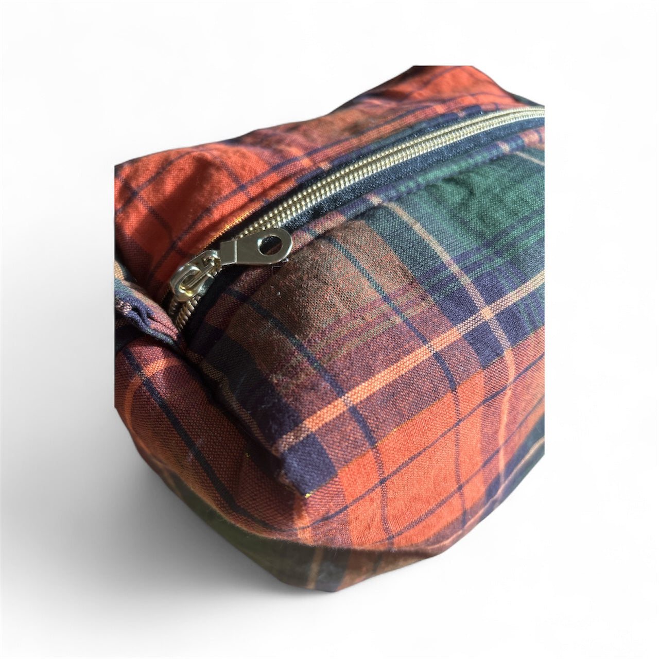 Close-up of a minimalist plaid canvas bag with orange and navy check pattern and zipper