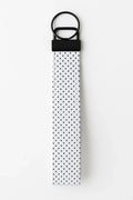 White fabric keychain wristlet with black polka dots and black metal hardware