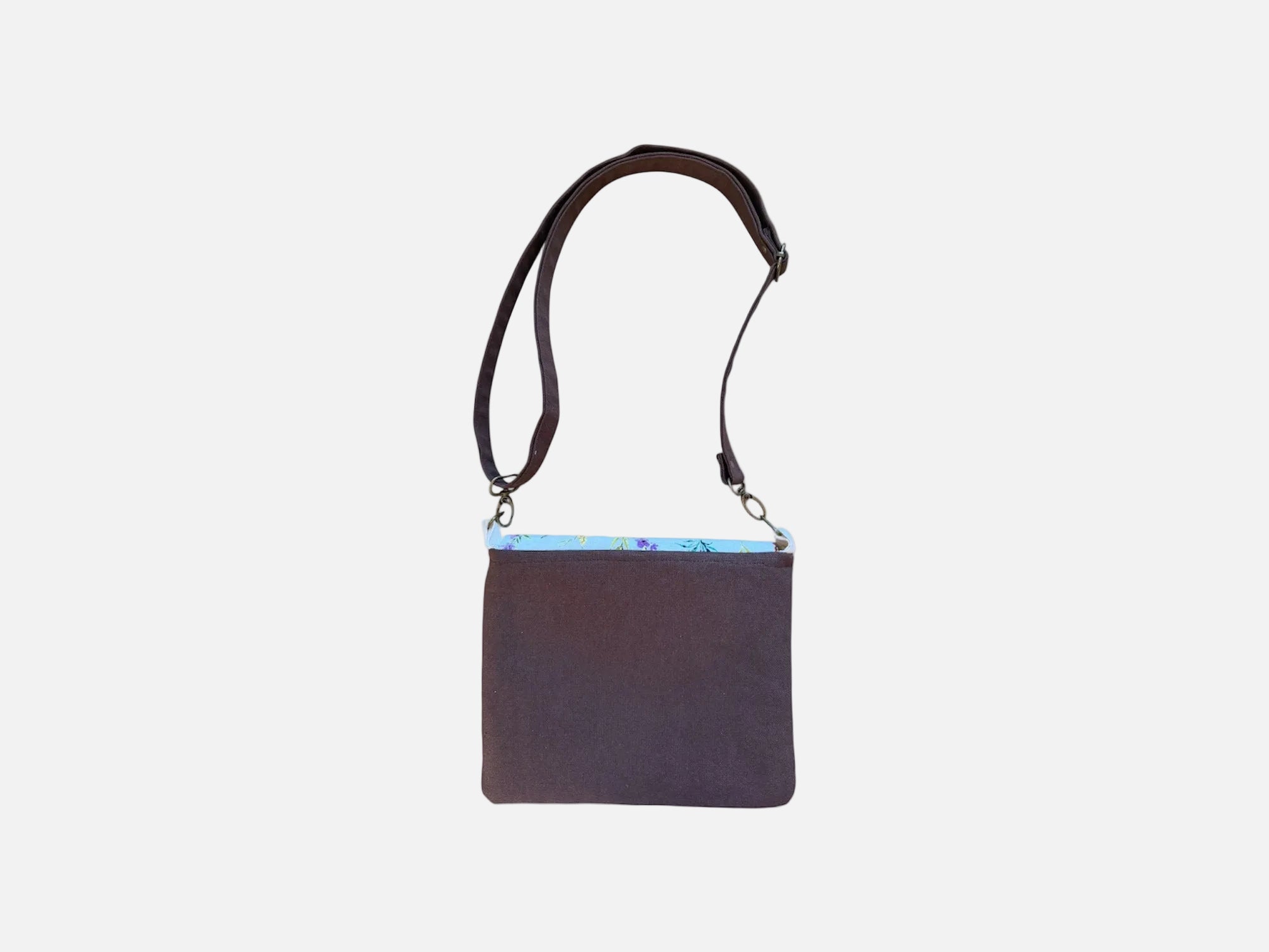 Back view of Cocoa canvas tote bag with black straps and floral snap closure