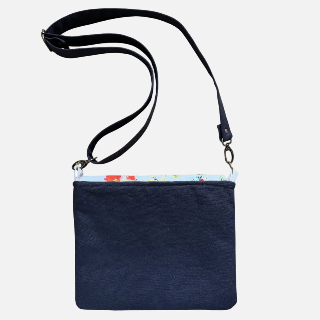 Back view of canvas tote bag with floral pocket and black straps