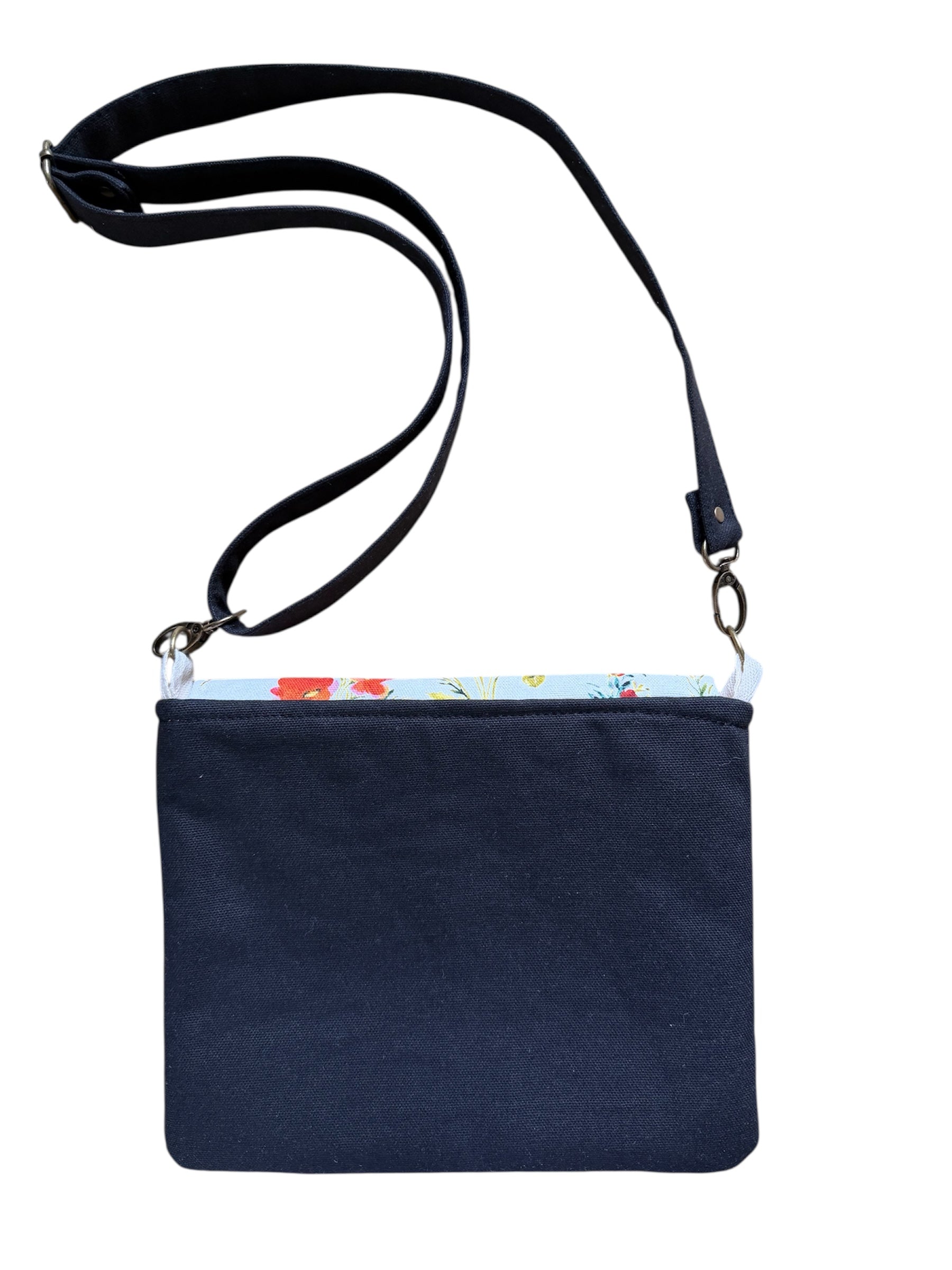 Back view of canvas tote bag with floral pocket and black straps