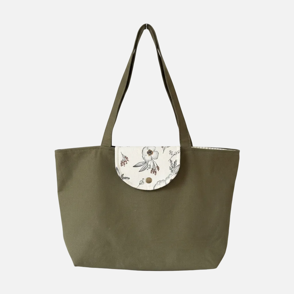 Green tote bag with floral flap on a white background